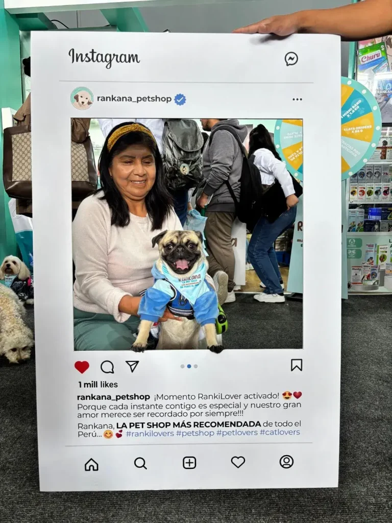 Señora sosteniendo a un perro Pug con casaca azul y bandana de Rankana Pet Shop.