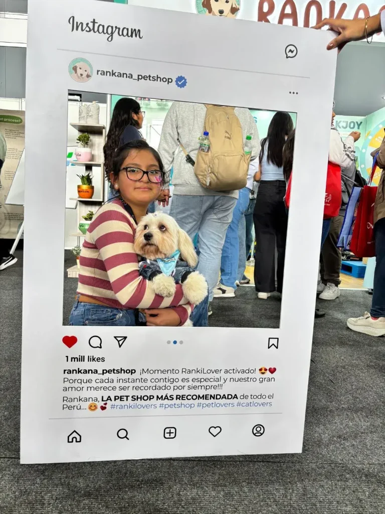 Niña con lentes abrazando cariñosamente a su perro blanco en el stand de Rankana.