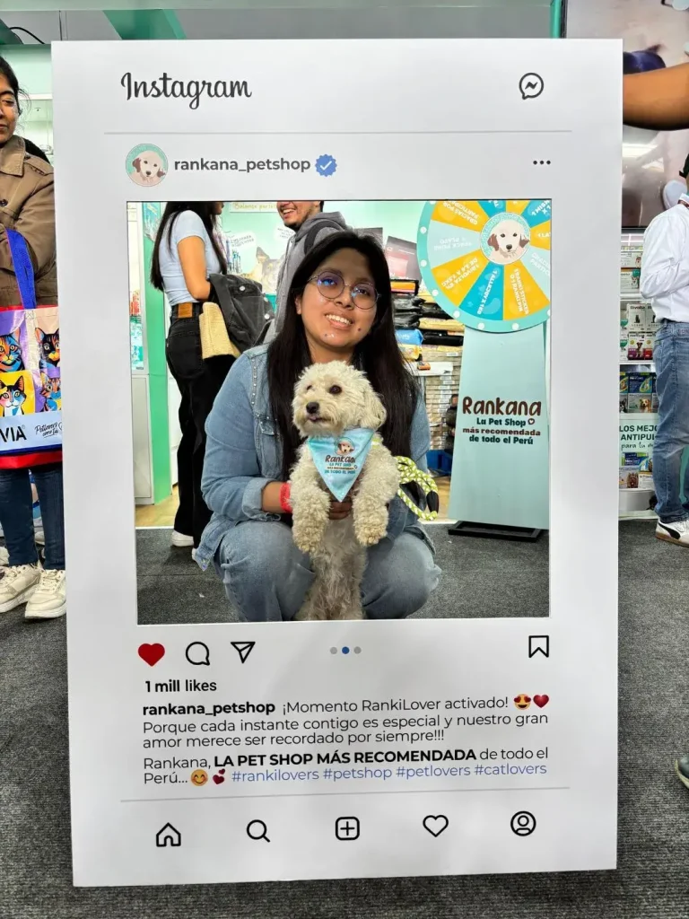 Cliente con su perro Poodle blanco luciendo una pañoleta celeste de Rankana en un evento de mascotas.